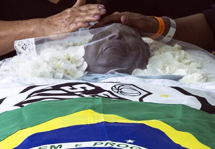 Una bandera nacional de Brasil y una del club Santos envuelven el cuerpo de la leyenda del fútbol Pelé. Foto:EFE