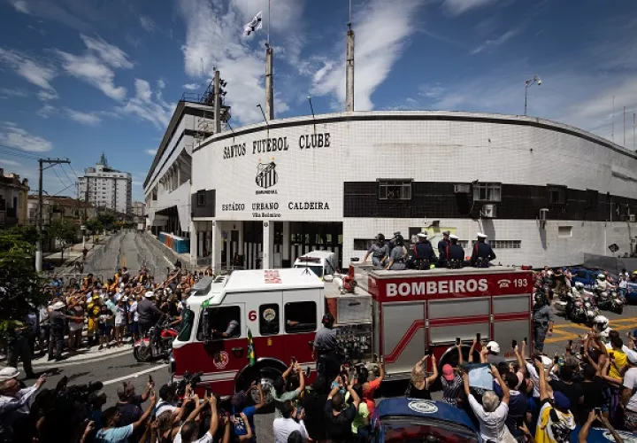 Un camión de bomberos que transporta el féretro con el cuerpo de la leyenda del fútbol Edson Arantes do Nascimento 'Pelé encabeza hoy el cortejo fúnebre que recorrerá algunas calles de la ciudad, rodeado de miles de aficionados, en dirección al cementerio 