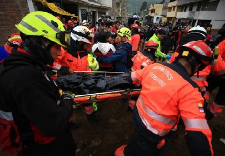Rescatistas trasladan  el cuerpo de una niña fallecida en el alud, en Alausí (Ecuador). Foto: EFE
