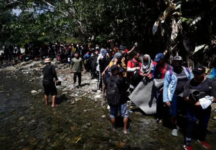 Personas migrantes esperan para ser trasladados en canoa en el Darién. Foto: EFE