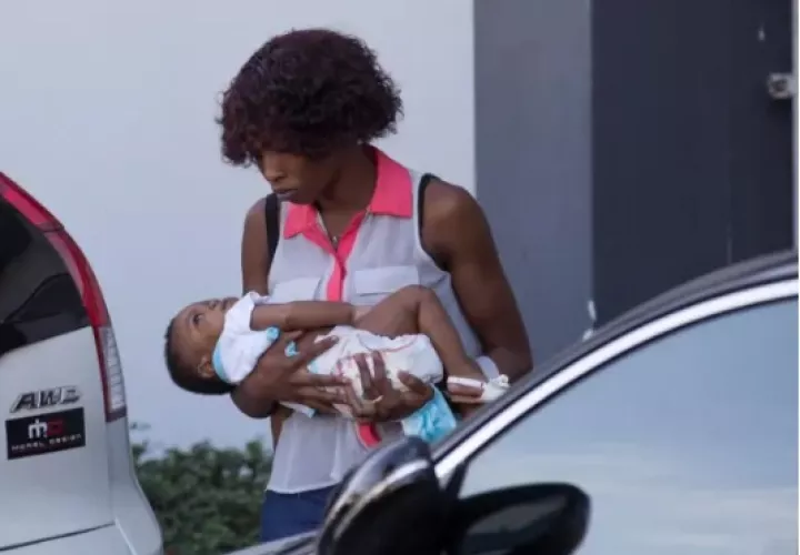 Una mujer, con su bebé en brazos, camina en el Hospital Materno Infantil San Lorenzo de los Mina, en Santo Domingo. Foto: EFE 