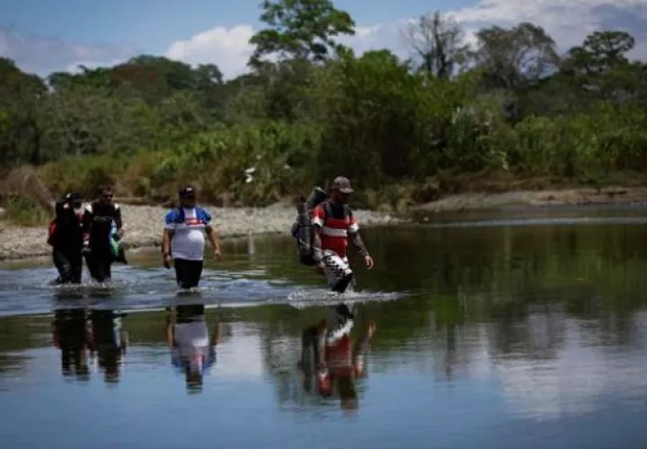 Migrantes cruzan el río Tuquesa, en Darién (Panamá). Foto: EFE