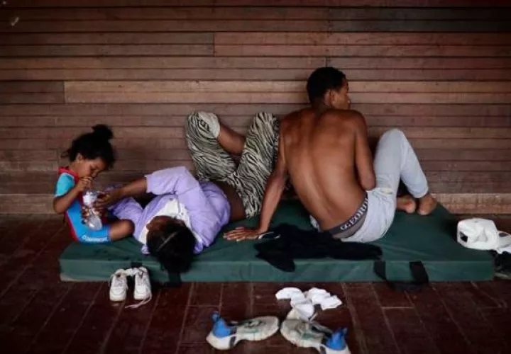 Una familia de migrantes venezolanos descansa en un albergue temporal tras cruzar la selva del Darién. Foto: EFE
