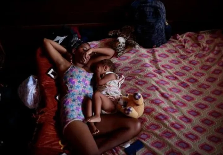 Una migrante venezolana junto a su hijo descansan en un albergue temporal tras cruzar la selva del Darién. Foto: EFE