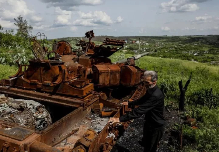 Un residente junto a un tanque ruso quemado, en el pueblo de Bohorodychne, región de Donetsk. Foto: EFE