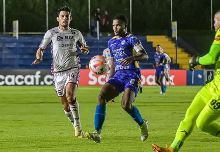 Kevin Calderón de Universitario (cent.) disputa el balón con Ariel Rodríguez de Saprissa. Foto:EFE