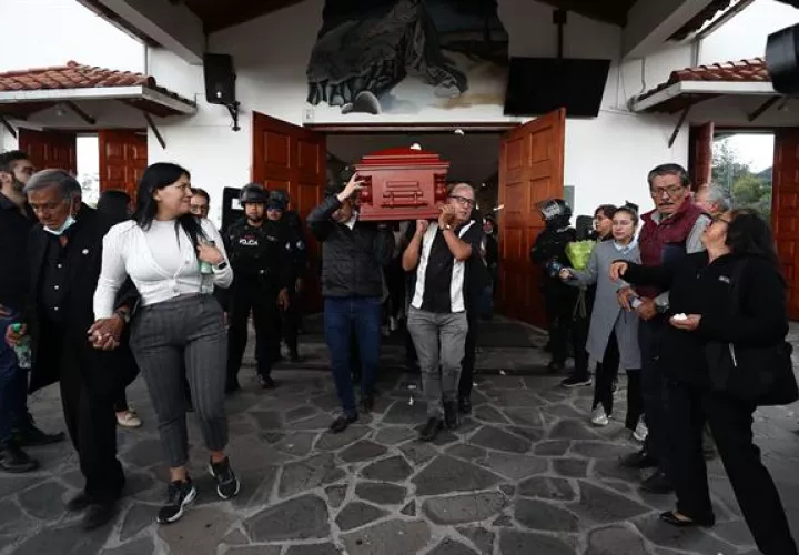 Varias personas cargan el féretro del candidato presidencial Fernando Villavicencio al termino de la misa de cuerpo presente.