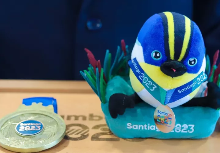 'Fiu' la mascota de los Juegos Panamericanos 2023 junto a una medalla de oro. Foto:EFE