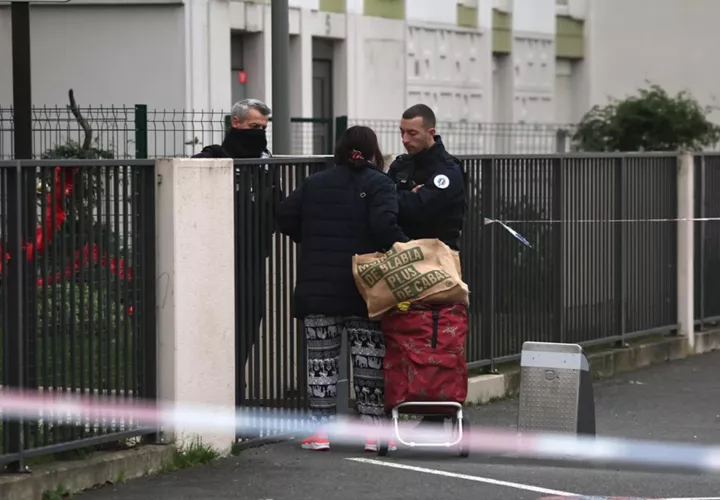 La policía pide documentación a una mujer a la entrada del edificio en el que se hallaron cinco cadáveres en Meaux, cerca de París. Foto: EFE