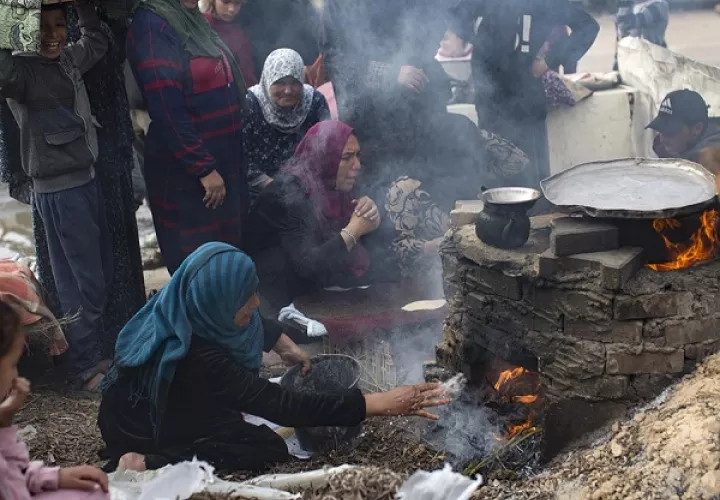 Palestinos desplazados internos preparan pan con leña ante la escasez de gas en los campos de refugiados de la ciudad de Rafah. Foto: EFE