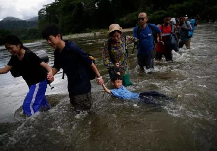 Migrantes cruzan el río Turquesa en Darién. Foto: EFE