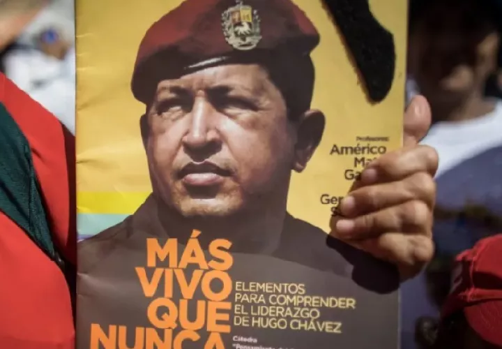Una persona sostiene un póster alusivo al fallecido presidente Hugo Chávez durante una movilización, en Caracas. Foto: EFE/Miguel Gutiérrez