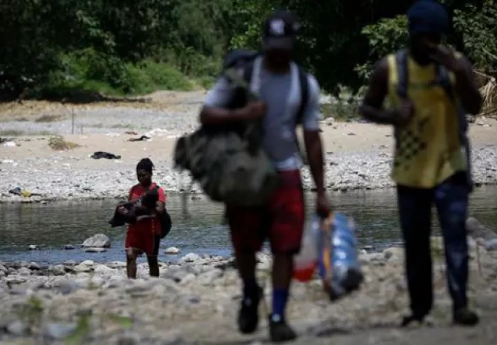 Migrantes cruzan el río Turquesa en Darién. Foto: EFE 