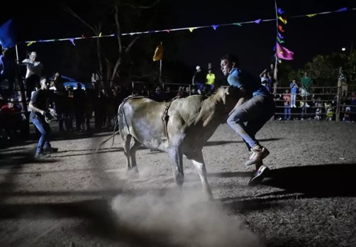 Jóvenes participan de una corrida de toros este sábado, durante el Festival Folclórico Nacional de La Mitra.