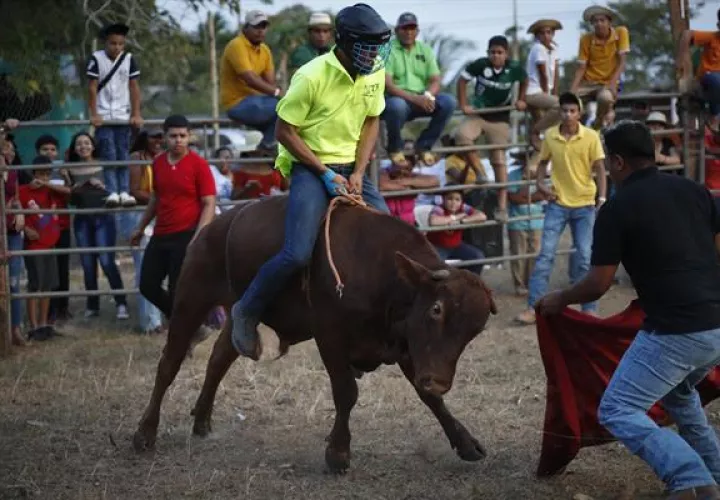 Jóvenes participan de una corrida de toros este sábado, durante el Festival Folclórico Nacional de La Mitra.