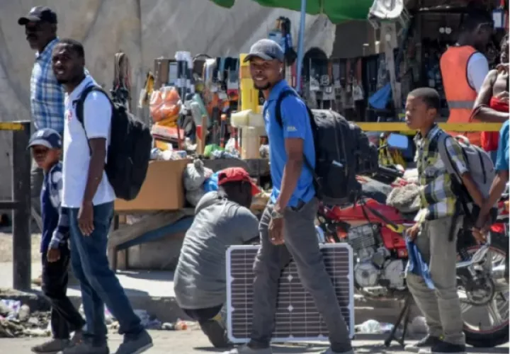 Personas caminan por una vía con sus pertenencias en Puerto Príncipe (Haití). Foto: EFE/Siffroy Clarens