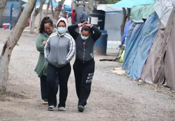 Mujeres migrantes caminan por un campamento ubicado a orillas del río Bravo en Matamoros, estado de Tamaulipas. Foto: EFE