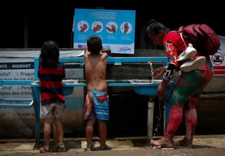 Una mujer y dos niños migrantes tras cruzar la selva del Darién. Foto: EFE