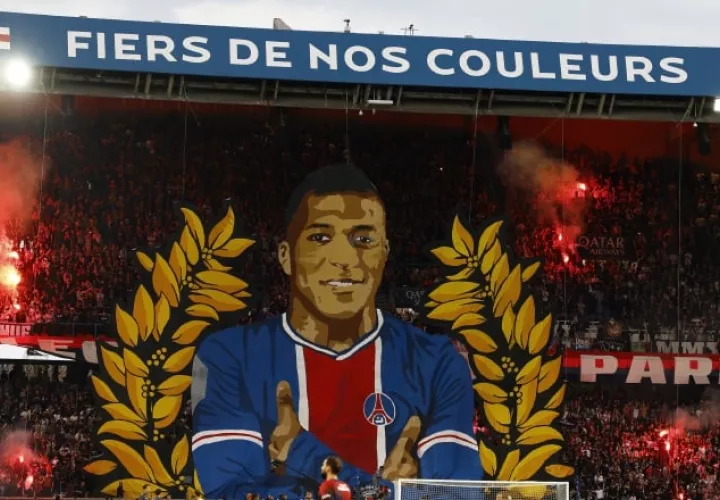 Los ruidosos aficionados radicales del fondo Auteuil desplegaron un enorme tifo con Mbappé de medio cuerpo rodeado de unos laureles y encendieron bengalas rojas, y el jugador fue a saludarles y agradecerles el gesto. Foto: EFE