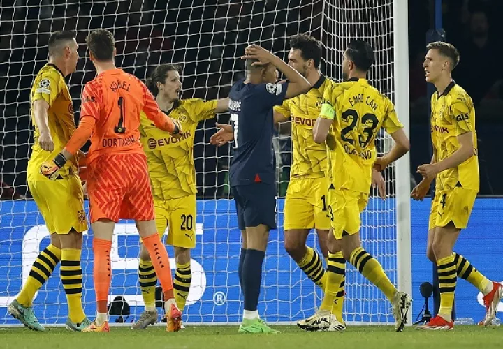 Kylian Mbappé se lamenta rodeados de jugadores del Dortmund la eliminación de su equipo. Foto: EFE