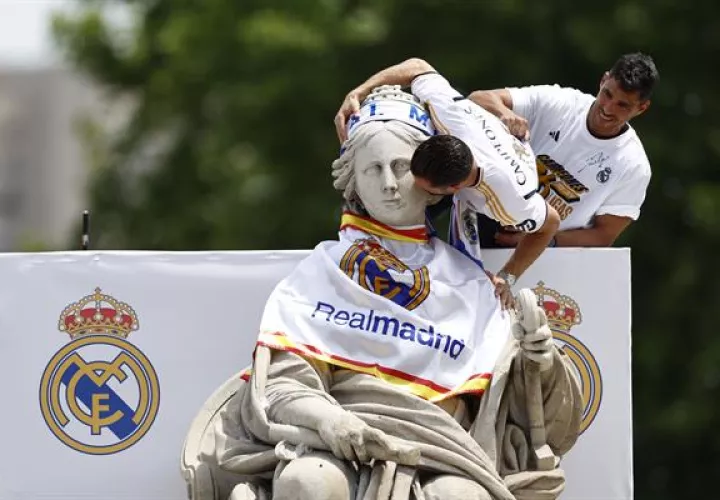Nacho Fernández coloca la bufanda a la estatuta de la diosa Cibeles en Madrid. Foto: EFE
