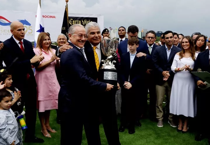 El presidente Mulino (der.) entrega a Eric Antonio Del Valle la copa del ganador. Foto: Víctor Arosemena. 