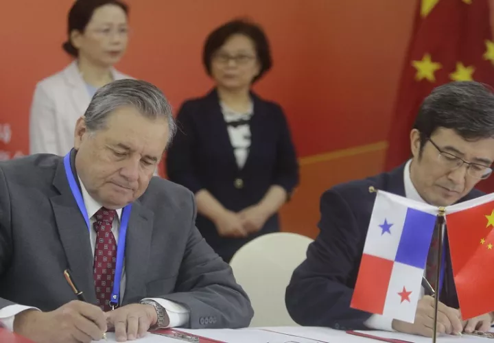 El director general de Animalfeeds, Brian Murtagh (i), y el subdirector de Servicios postales y de telecomunicaciones nacionales de China, Li Jingyi, firman un documento en Panamá. Foto: EFE