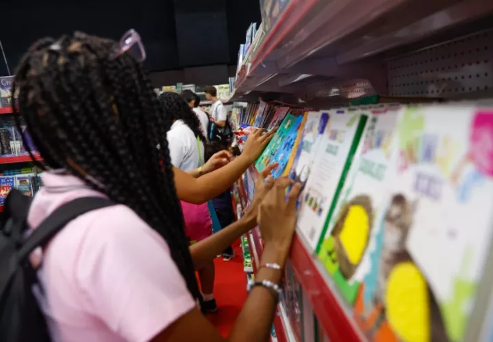 Una mujer observa un libro en la XX Feria Internacional del Libro en el Centro de Convenciones ATLAPA este 13 de agosto de 2024, en Ciudad de Panamá (Panamá). Foto: EFE / Bienvenido Velasco 