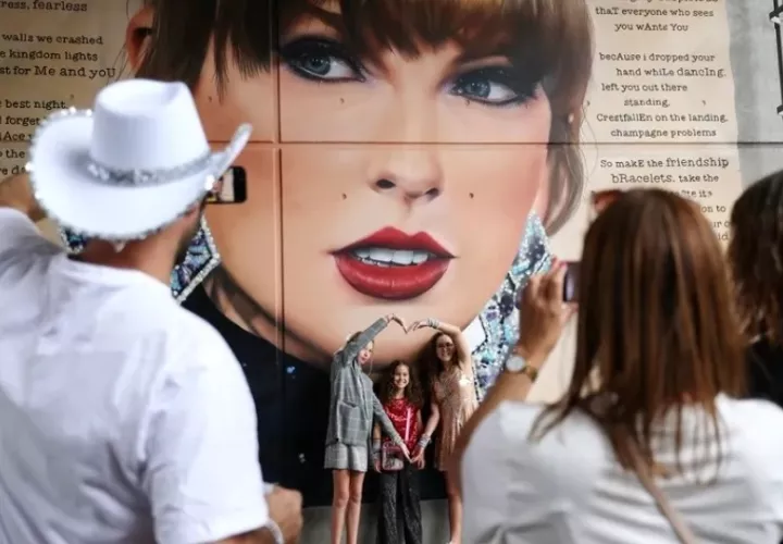 Fans de Taylor Swift observan un mural de la cantante estadounidense. Foto: EFE / EPA / Andy Rain