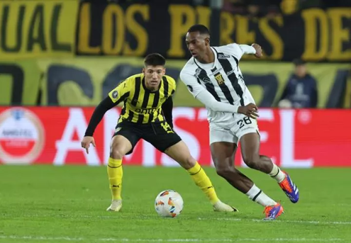 Sergio Damián García (i) de Peñarol disputa el balón contra el panameño Abdiel Ayarza de The Strongest. Foto: EFE