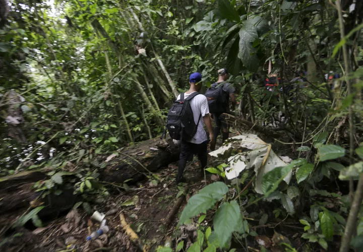   Migrantes de diferentes nacionalidades cruzan un campamento en plena selva del Darién, frontera natural entre Colombia y Panamá. Foto/Carlos Lemos/EFE