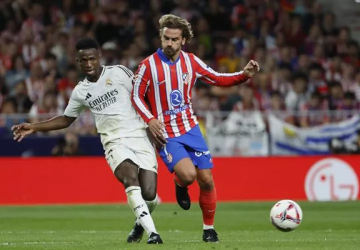 El delantero del Atlético de Madrid Antoine Griezmann (der.)  disputa el balón contra  el delantero brasileño del Real Madrid Vinicius Jr. (izq.). Foto: EFE