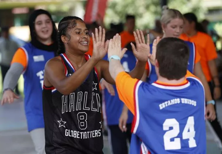  Kay 'Sushine' West del equipo de baloncesto Harlem Globetrotters, saluda a un joven durante un juego de exhibición contra el equipo de Olimpiadas Especiales de Panamá. Foto: EFE