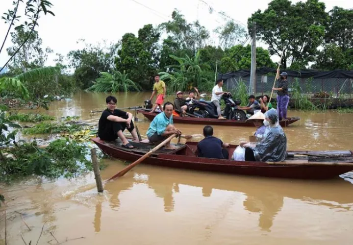 Residentes locales son evacuados en una calle inundada en Hanoi. Foto: EFE
