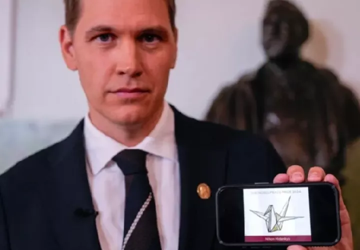 El presidente del Comité Nobel noruego, Jorgen Watne Frydnes, posa con una fotografía de la organización ganadora del Premio Nobel de la Paz 2024. Foto: EFE