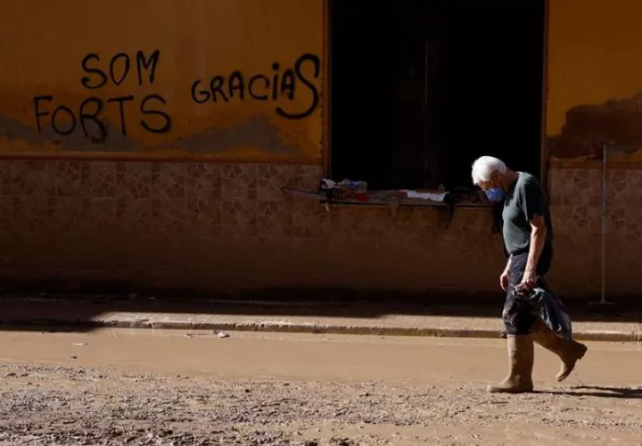 Un hombre camina por una calle embarrada en Paiporta (Valencia). Foto: EFE