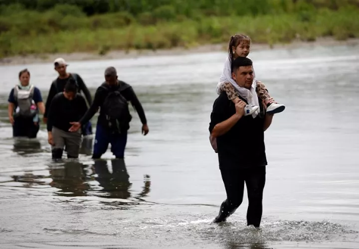 Migrantes cruzan el río Tuquesa luego de atravesar la selva del Darién, en el Darien (Panamá). EFE/ Bienvenido Velasco