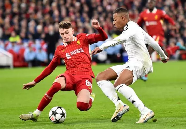 Conor Bradley del Liverpool (izq.) marca fuertemente a Kylian Mbappé del Real Madrid, en el partido de la Champions League. Foto: EFE