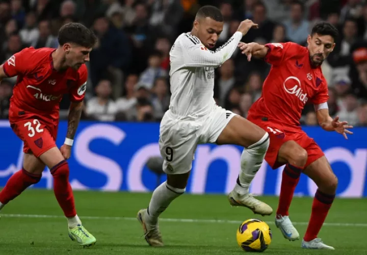 Kylian Mbappé (9) conduce el balón ante la marca de un jugador del Sevilla. Foto: EFE