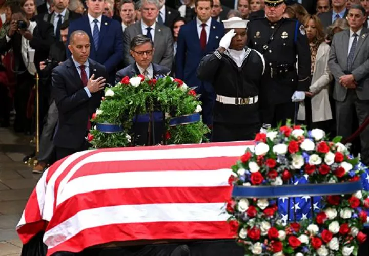 El líder de la minoría en la Cámara, Hakeem Jeffries (I), y el presidente de la Cámara, Mike Johnson, presentan una corona en nombre del Poder Legislativo en la ceremonia de capilla ardiente.