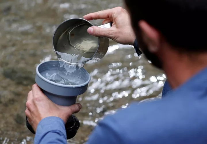 Un investigador sostiene muestras tomadas en el entorno de un río para detectar microplásticos. Foto: EFE