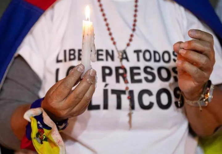 Una mujer que sostiene una vela durante una vigilia por los 'presos políticos' en la Universidad Central de Venezuela. Foto: EFE/Archivo