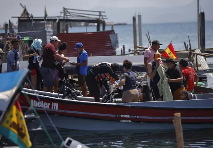 Migrantes venezolanos se suben a una embarcación en la isla Gardi Sugdub con destino a Colombia.  Foto: EFE/ Bienvenido Velasco