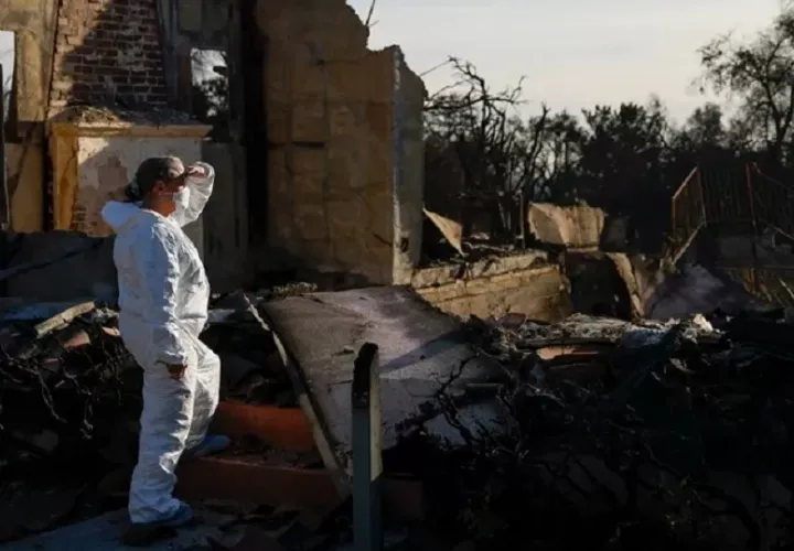 Vista de una mujer que revisa los escombros que dejó un incendio cerca de Los Ángeles en la casa de su hermana, el 21 de enero de 2025. EFE/Caroline Brehman