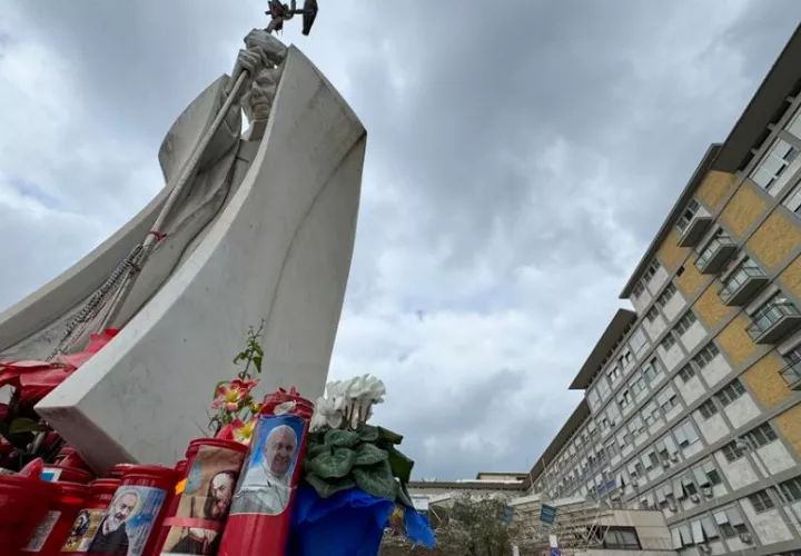 Velas y flores a las puertas del Hospital Gemelli de Roma donde permanece ingresado el papa Francisco. Foto: EFE