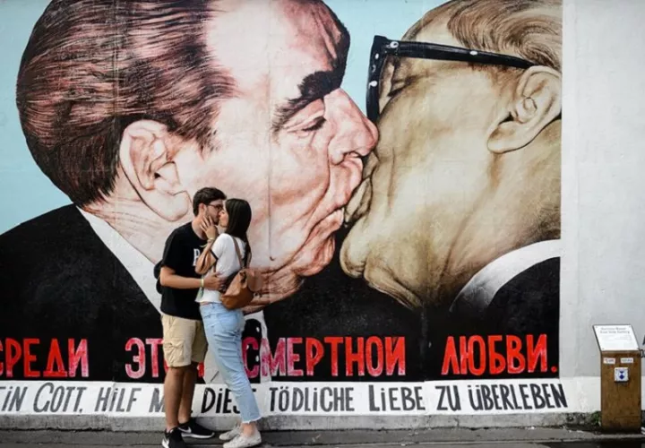 Dos turistas se besan frente al mural 'My God, Help Me to Survive This Deadly Love', también conocido como 'Beso fraternal', del artista ruso Dmitri Vrúbel. Foto: EFE