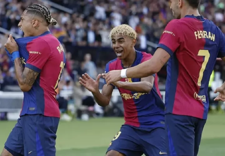 El delantero del Barcelona Raphinha celebra su segundo gol contra el Real Madrid con Lamine Yamal y Ferrán Torres. EFE/Alberto Estévez