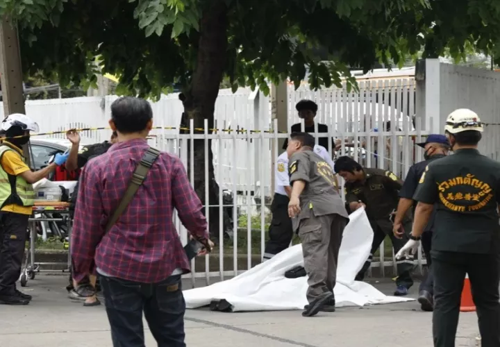 Miembros de los equipos de emergencia cubren a una víctima mortal del tiroteo registrado en un mercado de Bangkok. Foto:EFE