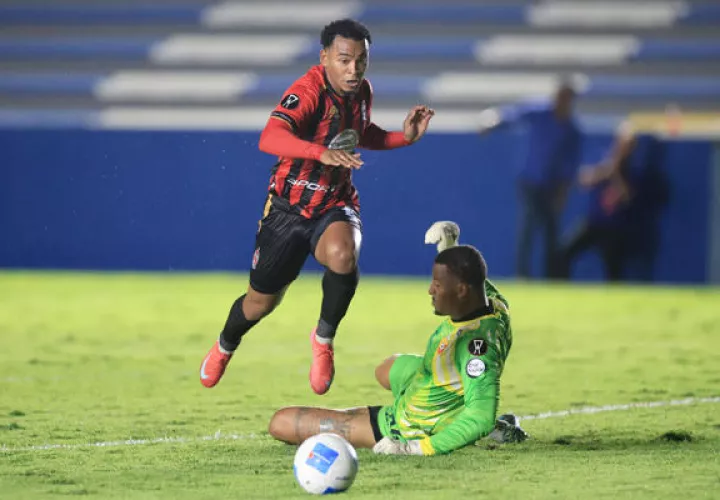 Yair Jaén, de Sporting, disputa el balón con el portero Anthony Walker, de Herediano. Foto: EFE