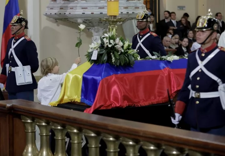  El hijo del fallecido senador y precandidato presidencial Miguel Uribe Turbay, Alejandro, lleva una flor frente el féretro.  EFE